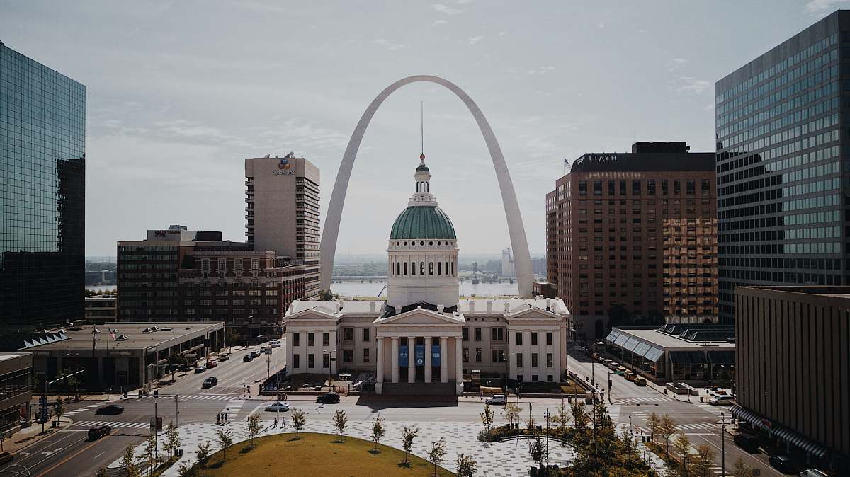 arch white and green dome cathedral in between high-rise buildings during daytime st. louis